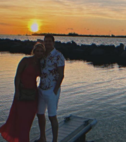 Alicia and Jason watching the sunset over the water